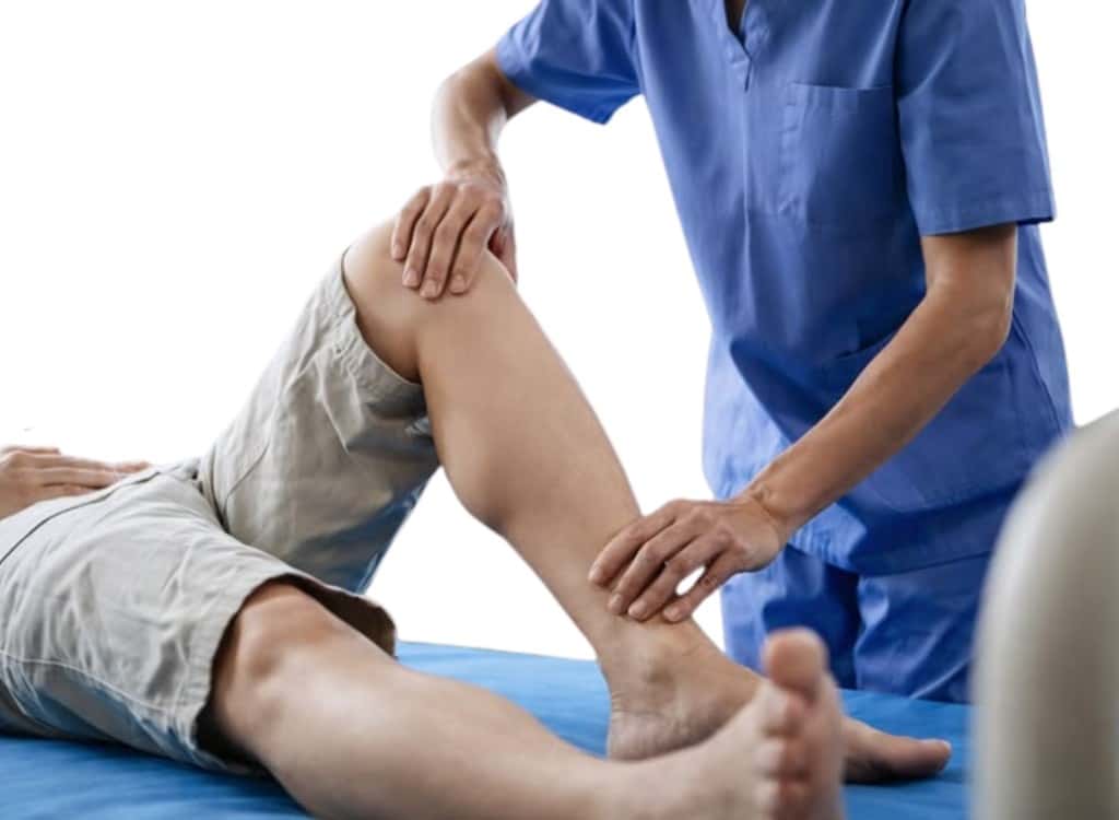 A clinician examining a patient's knee and lower leg
