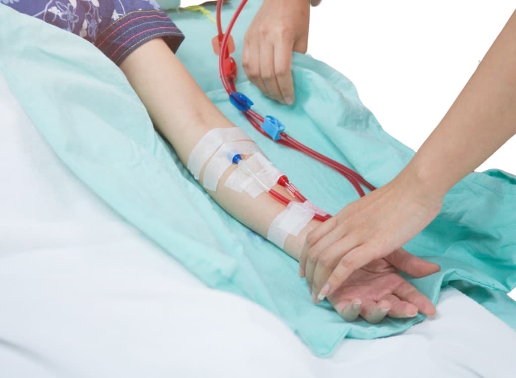 Dialysis blood lines taped to a patient's forearm